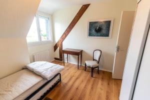 1 dormitorio con cama, escritorio y silla en Le Dolmen, en Crach