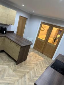 a kitchen with a wooden counter and a wooden door at Town Centre 2 bedroom apartment in Wick +5 photos