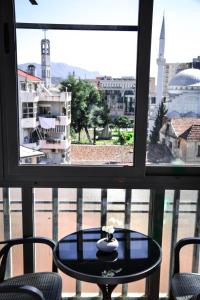 una mesa frente a una ventana con vistas a la ciudad en Horizont Apart-Hotel, en Shkodër