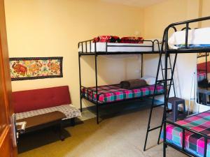 Cette chambre comprend 3 lits superposés et une chaise. dans l'établissement Hotel mango tree nearest Adam's peak, à Nallathanniya