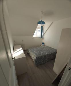 um pequeno quarto com uma cama e uma janela em Appartement à 100m plage de Puys dans ancien hôtel particulier. Place parking em Dieppe