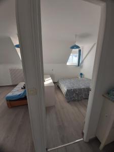 um quarto com uma cama, uma janela e um espelho em Appartement à 100m plage de Puys dans ancien hôtel particulier. Place parking em Dieppe