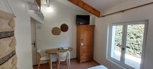 een kleine kamer met een tafel en een raam bij Gîte L'Olivier (Bastide Sainte Agnès) in Carpentras