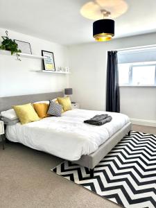 a bedroom with a bed with yellow pillows and a rug at Eden House & Aquila House - Beach Apartments & Suites in Saint Helier Jersey