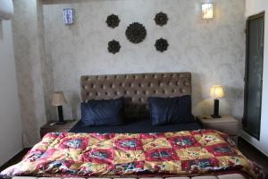1 dormitorio con 1 cama con edredón y 2 lámparas en Northern Bliss Haven: Your Ultimate Winter Escape at Islamabad Holiday Apartments - Choose from One & Two-Bed Units, en Islamabad