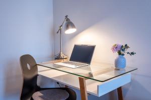 a desk with a laptop and a vase of flowers at Privatzimmer -Haus Schweiz- in Bonn in Bonn +40 photos