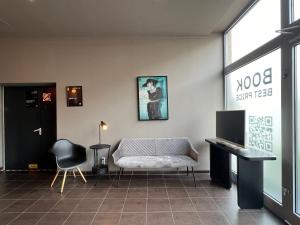 a room with a couch and a desk and a television at N8 ROOMS - by Leipzig Suites in Leipzig