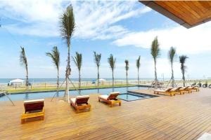 una piscina con sedie a sdraio e palme di Ecusuites Playa privada Room 1 Karibao a Playas
