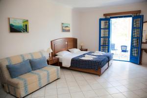 a bedroom with a bed and a couch at Blue Waves Studios in Kyra Panagia