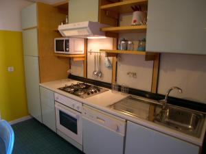 a kitchen with a stove and a sink and a microwave at Casa Carducci in Grado