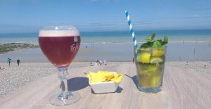 a glass of beer sitting on a table at the beach at maisonnette in Dieppe