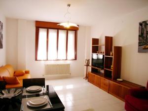 een woonkamer met een bank en een televisie bij Casa Carducci in Grado