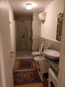 ein Badezimmer mit 2 WCs, einem Waschbecken und einer Dusche in der Unterkunft La casa di Fabri in Piombino