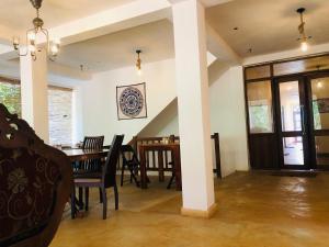 uma sala de jantar com mesa e cadeiras em Hotel mango tree nearest Adam's peak em Nallathanniya