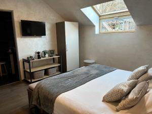 um quarto com uma cama com almofadas e uma janela em Les Olivades em Gap