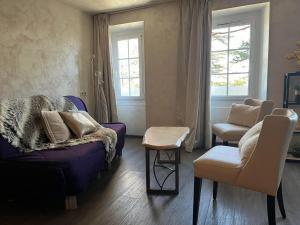 a living room with a purple couch and a chair at Les Olivades in Gap