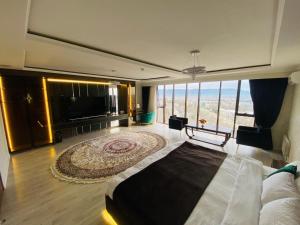 BALAND HOTEL DUSHANBE في دوسهانبي: غرفة نوم كبيرة بها سرير ونافذة كبيرة