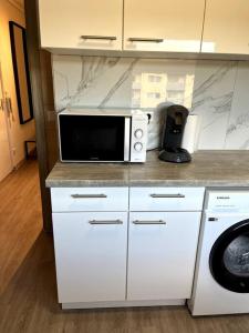 a kitchen with a microwave and a washer and dryer at Familienwohnung nähe Europapark, Messe, Gifiz See in Offenburg