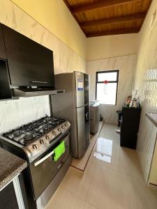 a kitchen with a stainless steel stove and refrigerator at Refugio Lago de Tota in Cuítiva