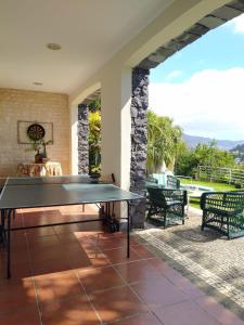 a ping pong table on the patio of a house at BioFuncho in Funchal