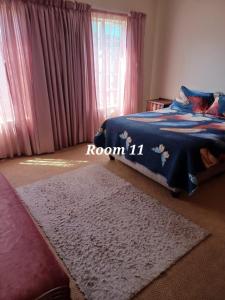 a bedroom with a bed with a blue blanket and a rug at 999 Pretorius street in Pretoria
