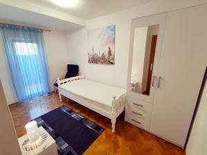 een slaapkamer met een wit bed en een spiegel bij Wohnung in Pula mit Terrasse, Garten und Grill in Pula