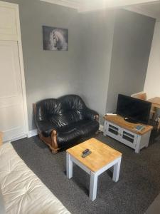 a living room with a leather couch and a coffee table at Lovely Getaway Apartment in Wisbech in Wisbech