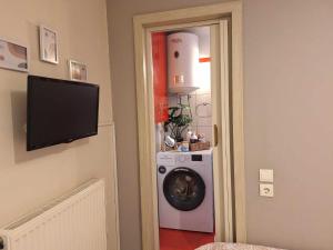 a laundry room with a washing machine and a tv at Apartment near the sea, Volos in Volos