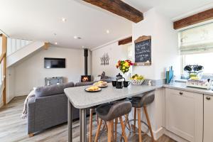 een keuken en een woonkamer met een tafel en stoelen bij Woodland Cottage in Llanasa