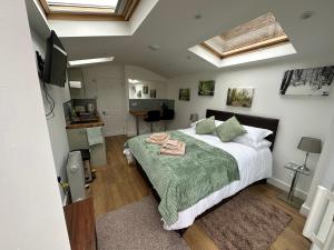 a bedroom with a large bed with a green blanket at Little Hawthorns in New Alresford