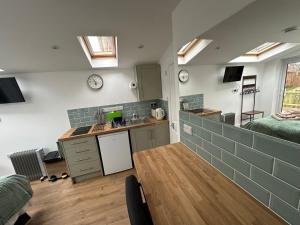 a kitchen with a table and a kitchen with skylights at Little Hawthorns in New Alresford
