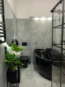 a bathroom with a black tub and plants in it at LOFT w centrum z jacuzzi in Wrocław