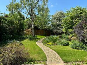 a garden with a stone path in the grass at Little Hawthorns in New Alresford