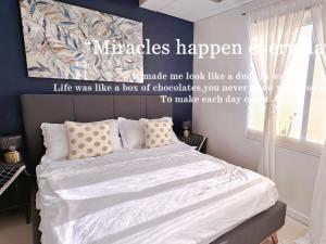 1 dormitorio con 1 cama grande con sábanas blancas en LarisZone-Luxury Courtyard Villa, en Manila