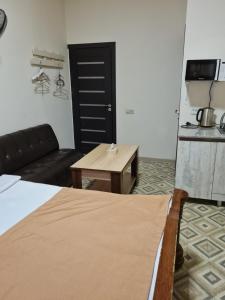 a room with a bed and a couch and a table at Budget Hotel Rooms In Yerevan in Yerevan