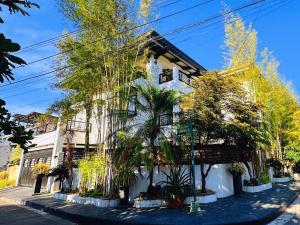 ein weißes Gebäude mit Bäumen davor in der Unterkunft LarisZone-Luxury Courtyard Villa in Manila