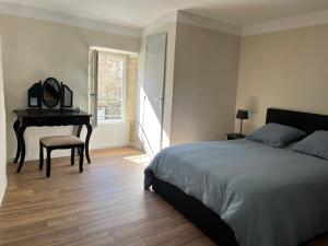 - une chambre avec un lit, une table et un piano dans l'établissement Maison de village, à Lédenon