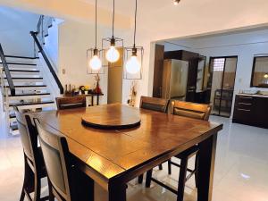 ein Esszimmer und eine Küche mit einem Holztisch und Stühlen in der Unterkunft LarisZone-Luxury Courtyard Villa in Manila