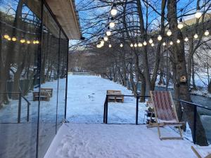 a building with a bench and lights in the snow at Lightwood cabins in Kʼareli