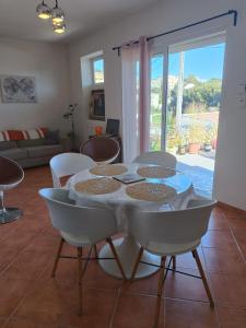 ein Esszimmer mit einem Tisch und Stühlen sowie ein Wohnzimmer in der Unterkunft Chambre dans maison individuelle vue sur le massif de l'étoile in Marseille