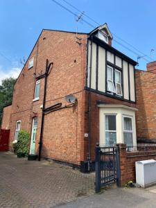 a red brick house with a black and white at Rose House in Derby