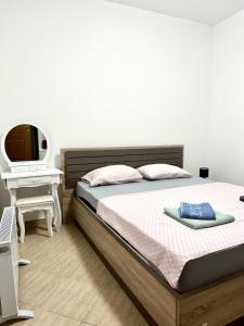 a bedroom with a bed and a desk with a television at Apartman Marko in Risan