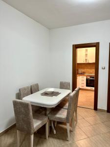 a dining room with a white table and chairs at Apartman Marko in Risan