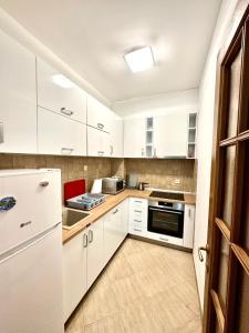 a white kitchen with white cabinets and appliances at Apartman Marko in Risan