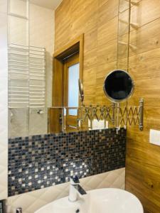 ein Bad mit einem Waschbecken und einem Spiegel in der Unterkunft Jacuzzi Glass-House Central Station in Krakau