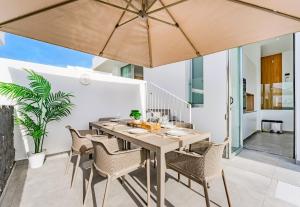 a dining room with a table and chairs and an umbrella at Villa Larisa in Callao Salvaje
