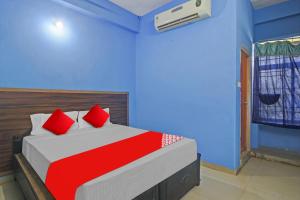 Karīmnagar的住宿－Hotel Satya Inn，一间卧室配有红色枕头的床