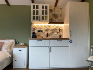 a kitchen with white cabinets in a bedroom at ToVouno in Plaka