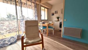une chambre avec une table et une chaise ainsi qu'une cuisine dans l'établissement Vaux sur Mer - EMPLACEMENT de CHOIX - APPARTEMENT - PLAGE de NAUZAN, à Vaux-sur-Mer