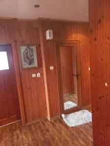ein leeres Zimmer mit Holzwänden und einer Tür in der Unterkunft Къща село Катунци in Sandanski